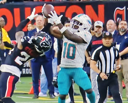 Tyreek Hill has his hands on the ball, but Derek Stingley Jr. took it away for the interception that sealed the Dolphins' loss at Houston.