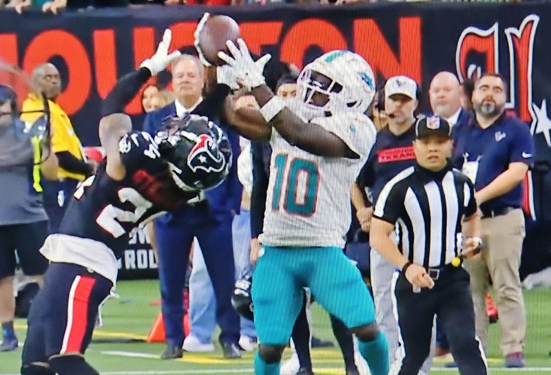 Tyreek Hill has his hands on the ball, but Derek Stingley Jr. took it away for the interception that sealed the Dolphins' loss at Houston.